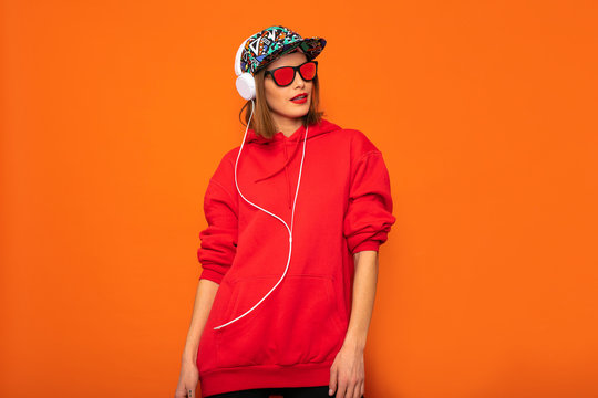 cool hipster girl with colored hat on orange