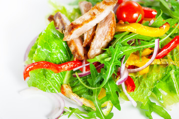 Delicious salad with meat, tomatoes and greenery on white