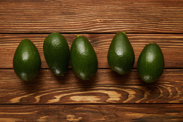top view of avocados on wooden background
