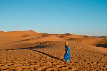 Berber walking the stunning sand dunes of Sahara desert
