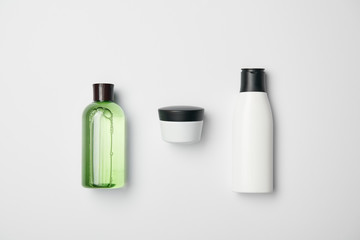 Top view of different cosmetic bottles on white background