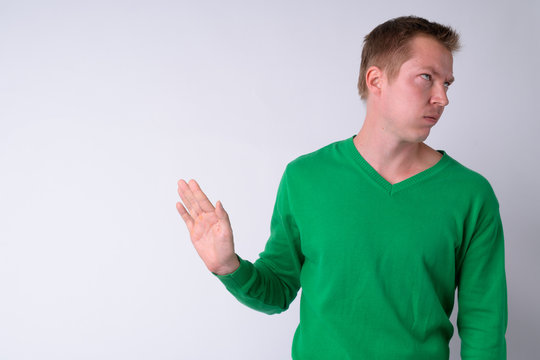 Portrait of annoyed young man showing stop gesture