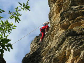 young woman climbing on a rock