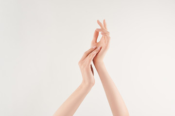 Partial view of well-cared female hands on white background