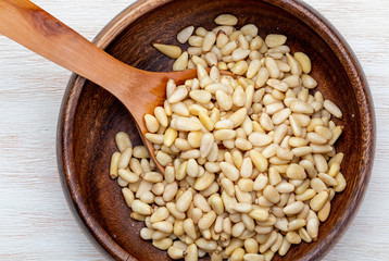 Peeled pine nuts. Aerial view (from above, top view). Foreground (Close-up). Wood background Rustic, natural and homemade appearance.