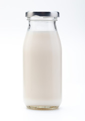 Milk in glass bottle. With cap. Isolated on white background.