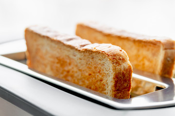 Healthy fashion food of breakfast. Toast in a toaster. Toaster with tasty breakfast toasts on the table