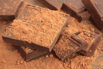Brown chocolate pieces with cocoa powder closeup