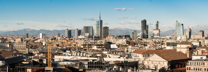 Milan skyline. Large panoramic view of Milano city, Italy. The mountain range of the Lombardy Alps in the background. Italian landscape.
