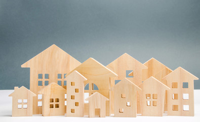 Miniature wooden houses. Real estate. City. Agglomeration and urbanization. Real Estate Market Analytics. Demand for housing. Rising and falling home prices. The growth of the city and its population