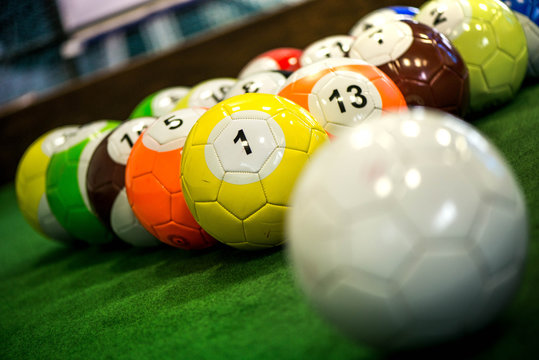 Shot of foot pool balls standing on green table. Foot Pool is the hybrid combination of pool and soccer. Big billiard balls. 