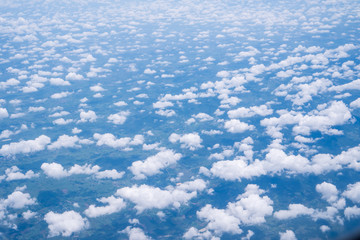 Sky scape cloudscape from aerial airplane shot of blue clouds. View flying above moutain from windows over Loei, Thailand.