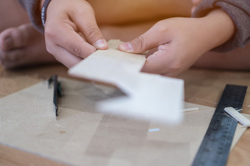 School children are working on woodwork. With a knife cutter and a ruler as a working device, Wood processing