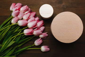 Pink tulips and candle on the wooden background