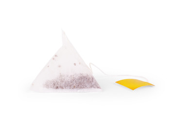 Closeup triangle Tea bag with yellow label Isolated on white background