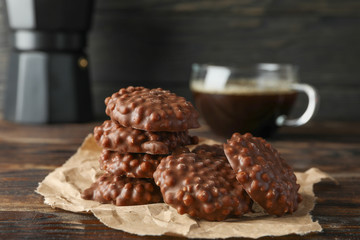 Tasty chocolate cookies with cup of coffee on wooden table, close up