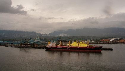 ship next to sulphur piles in vancouver harbor