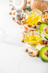 Healthy vegan fat food sources, omega3, omega6 ingredients - almond, pecan, hazelnuts, walnuts, olive oil, chia seeds, avocado, coconut,  banner copy space