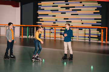 Preteen roller skaters practicing skating on rink together