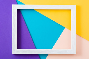 White wooden frame on colorful background. Copyspace. Mockup.

