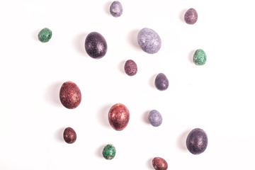 Brilliant Easter eggs in glitter of different colors on a white background.