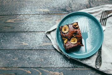 chocolate brownie on a beautiful plate dessert lies on a dark wooden background