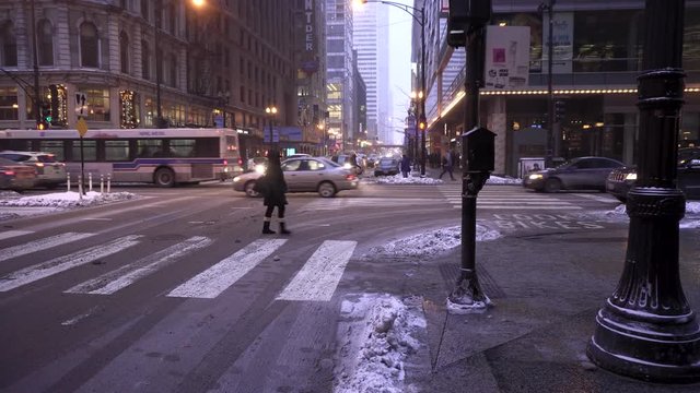 pedestrians brave the Chicago winter sub-zero temperature downtown at dusk.