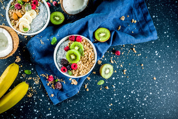 Homemade granola with chia seeds yogurt pudding, fresh fruit and berries, on dark blue concrete background copy space