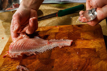 chef hands cut fish fillet by knife