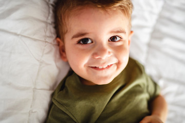 A two years old boy on bed portrait.
