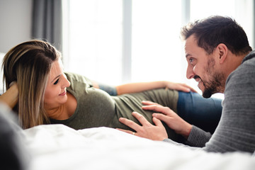 The parents in bed expecting a little baby, Romantic moments for pregnant couple
