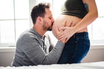 A Happy young man kiss to pregnant womans belly