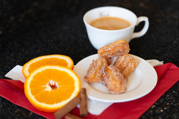 Spanish cuisine: churos and orange close-up on the table