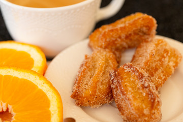 Spanish cuisine: churos and orange close-up on the table