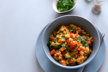 Healthy vegan bowl with quinoa, pumpkin, pepper and carrot on gray wooden background. Selective focus