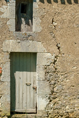 A large crack in the wall of a rustic outbuilding threatens its stability.