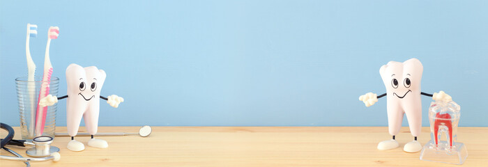 Dental care tools use for dentist and smiling healthy tooth in the clinic. Wooden blue background.