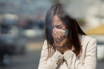 Asian woman are going to work.she wears N95 mask.prevent PM2.5 dust and smog.she is coughing
