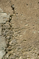 A large crack in the wall of a rustic outbuilding threatens its stability.