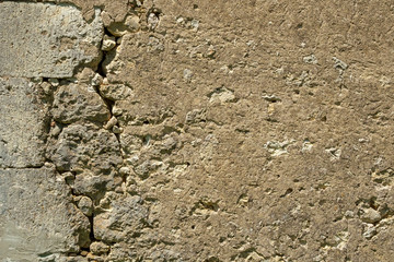 A large crack in the wall of a rustic outbuilding threatens its stability.