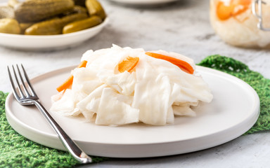 Fermented cabbage on a white plate close-up.