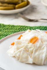 Fermented cabbage on a white plate close-up.