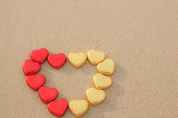 Chocolate color Lovely red golden heart on the beach. Background is a natural in real place, creative Valentine's Day Concept, tropical style background made in Phuket, Thailand.