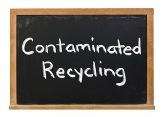 Contaminated recycling written in white chalk on a black chalkboard isolated on white