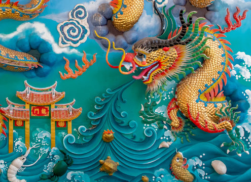 The close up of the colorful statue of  chinese dragon on the blue wall.Beautiful statue of dragon carved around temple pole in Chinese public temple.