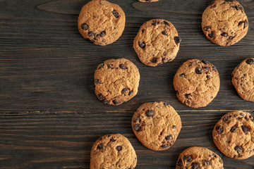 Delicious chocolate chip cookies on wooden background, flat lay. Copy space text