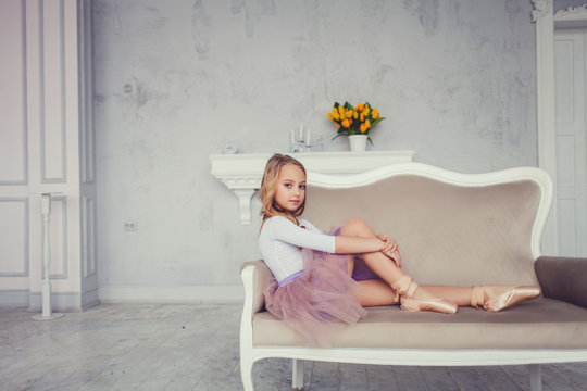 Portrait of little ballerina relaxing on chair, copy space.