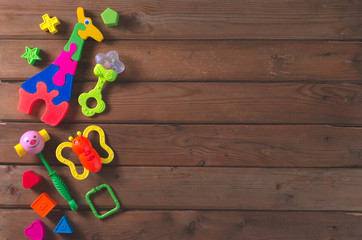 Top view or flat lay on colorful toys on dark wooden background with copy space.