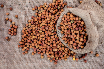 Close up shot of chickpea or chana or gram or Cicer arietinum in a gunny bag on a brown colored...