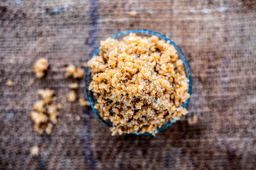 Close up of popular Indian & Asian sweet dish i.e. Malida or churma na ladu or moti chur na ladu in a bowl on brown surface.